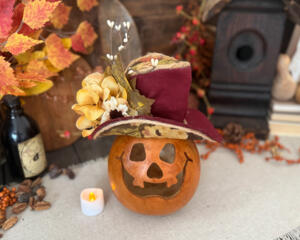 This is a hand carved pumpkin gourd for your fall table decorating. I have carved a happy face into the shell and made a autumn hat.